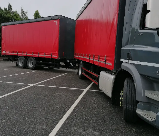 Two semi trucks parked in a parking lot.